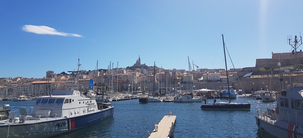 Alter Stadthafen in Marseille mit dem Wahrzeichen der Stadt im Hintegrund