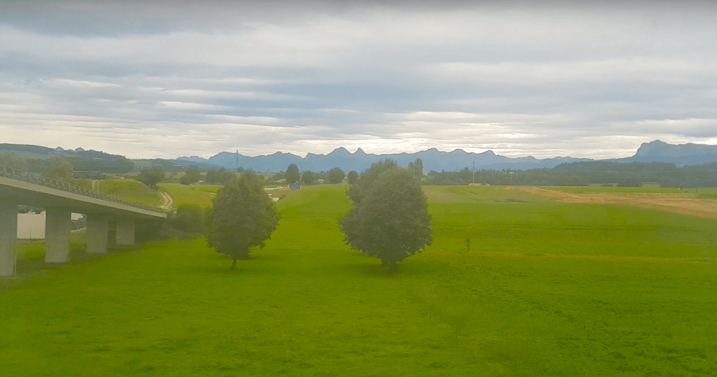Zugfahren in der Schweiz:  Naturlandschaft bei Blick aus dem Zugfenster